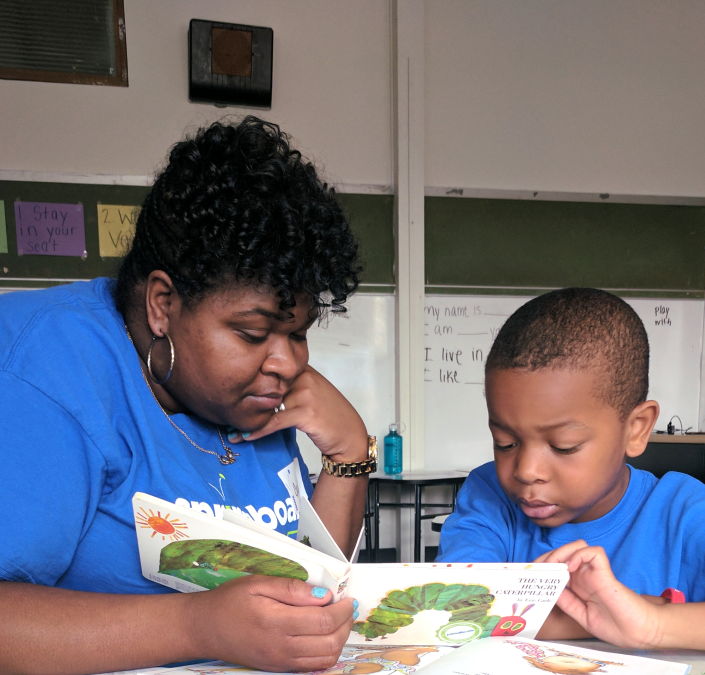 Mother and child reading a children’s book together in a classroom at a Springboard Collaborative family workshop